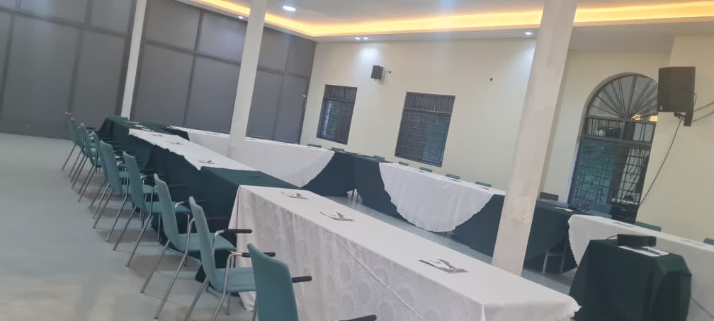 The conference hall set in a U-shape with white tablecloths and teal chairs