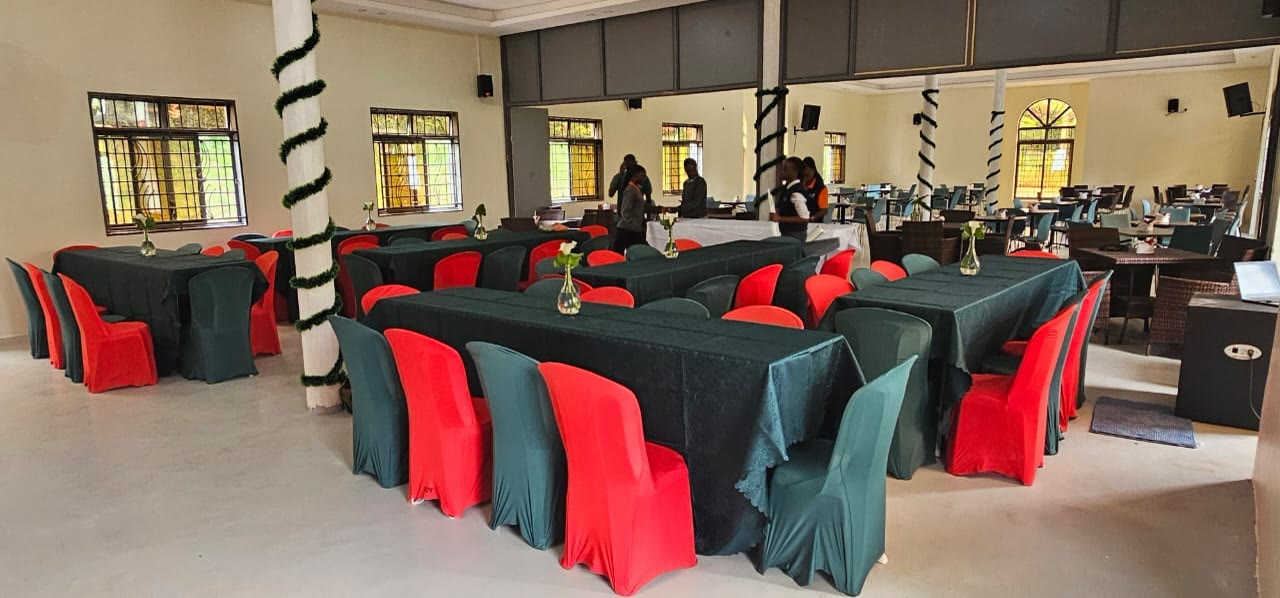The conference hall set for a banquet with red and green chairs