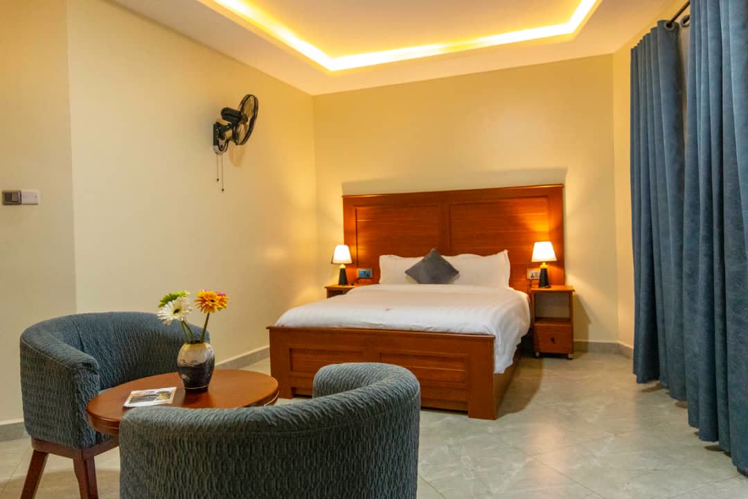 Armchairs and a small table at the foot of the bed