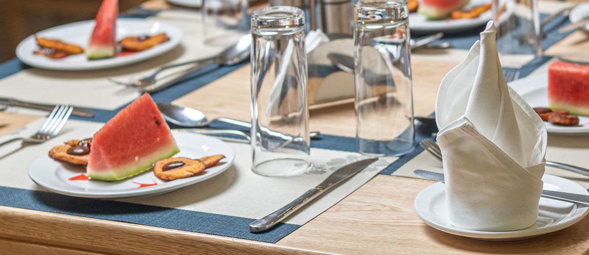 A table set with watermelon and fried plantain to start