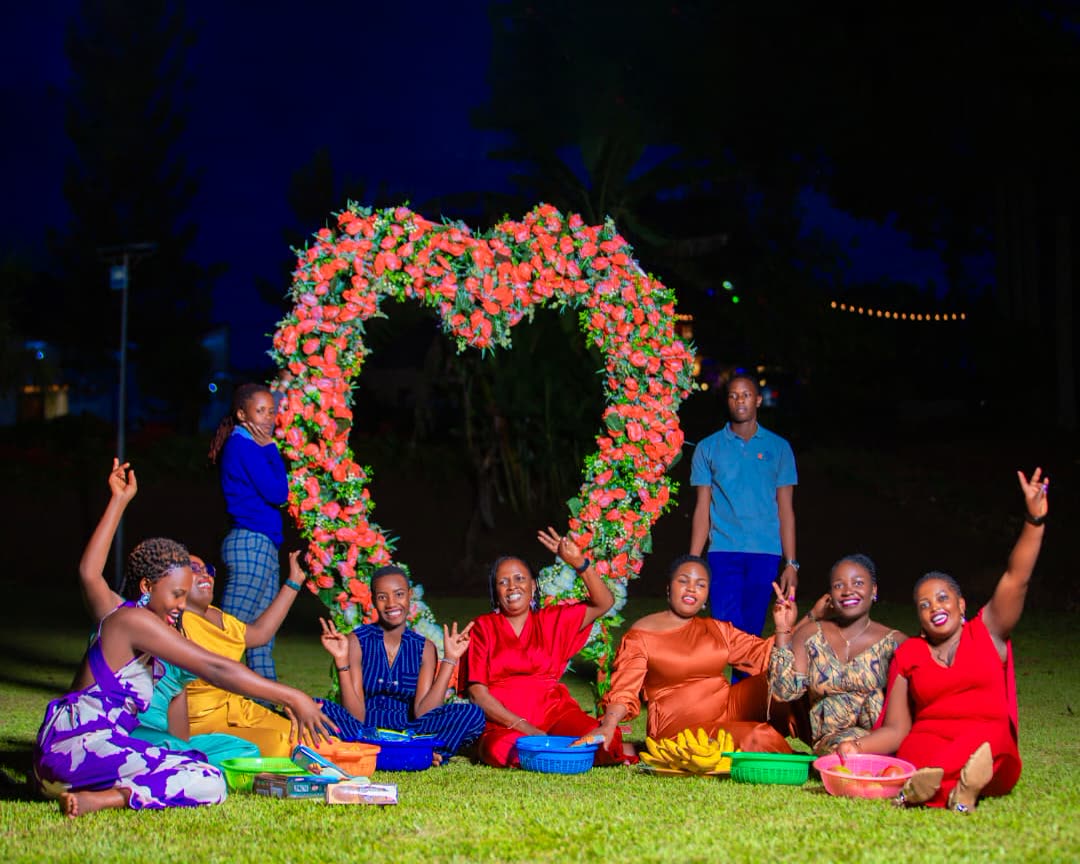 Friends celebrating at night in front of a flower heart arch