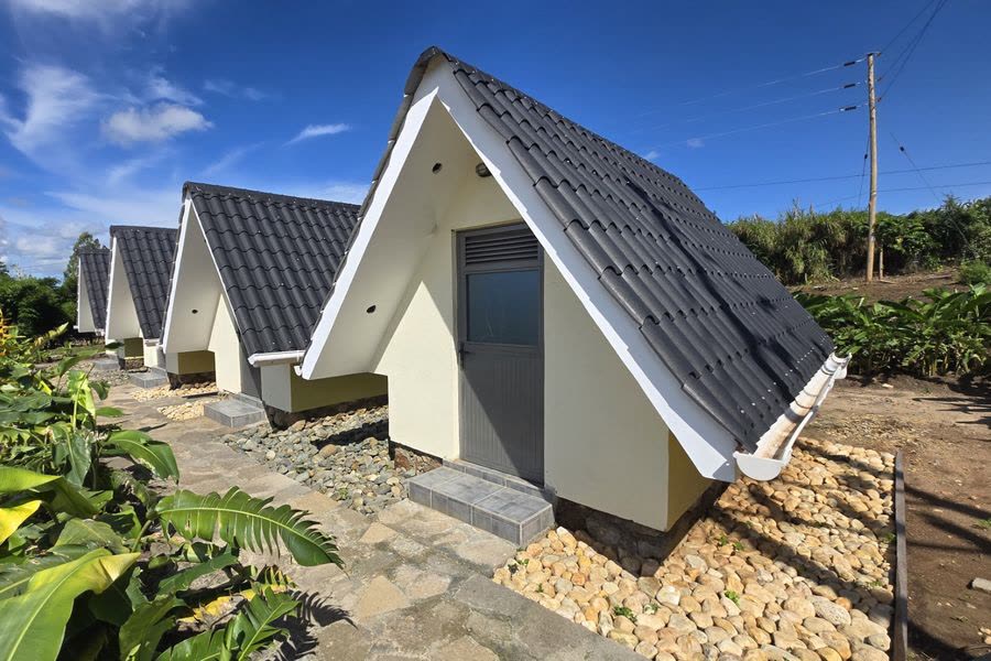 A row of white A-frame studios with dark tiled roofs