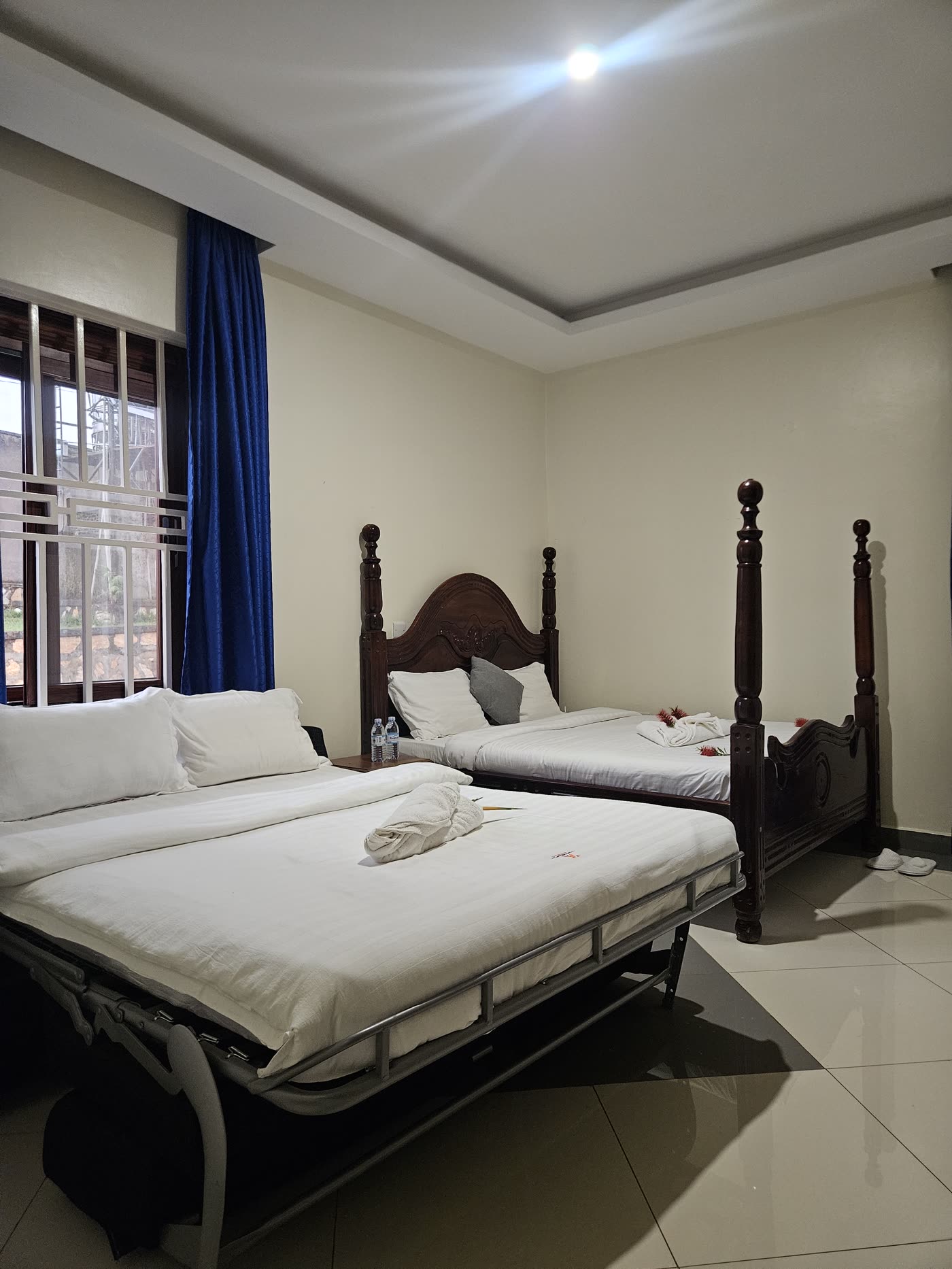 A four-poster double bed and a day bed under blue curtains