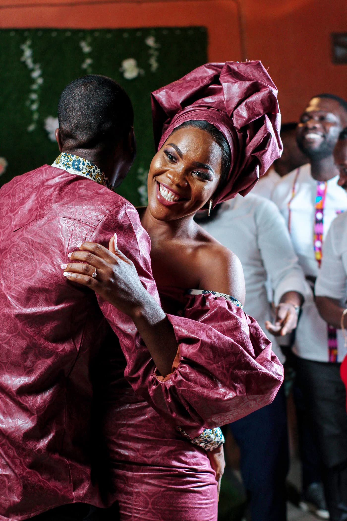 A newly married couple dancing in traditional attire with guests around them
