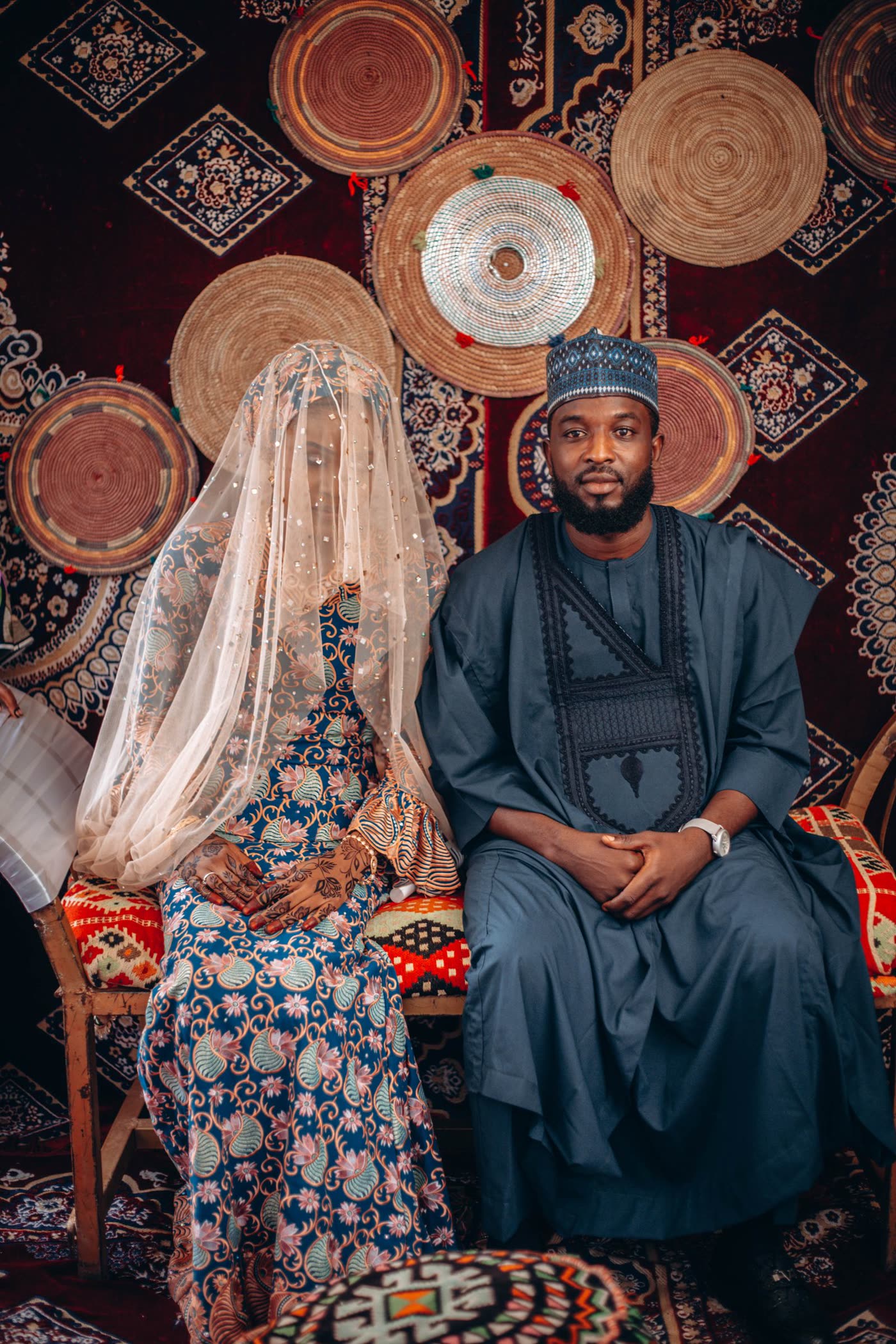 A couple seated in traditional African wedding attire